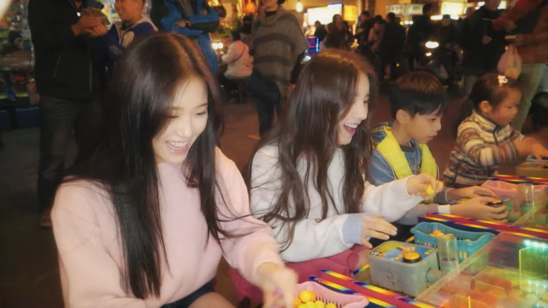 Heejin and Hyunjin playing an arcade game.